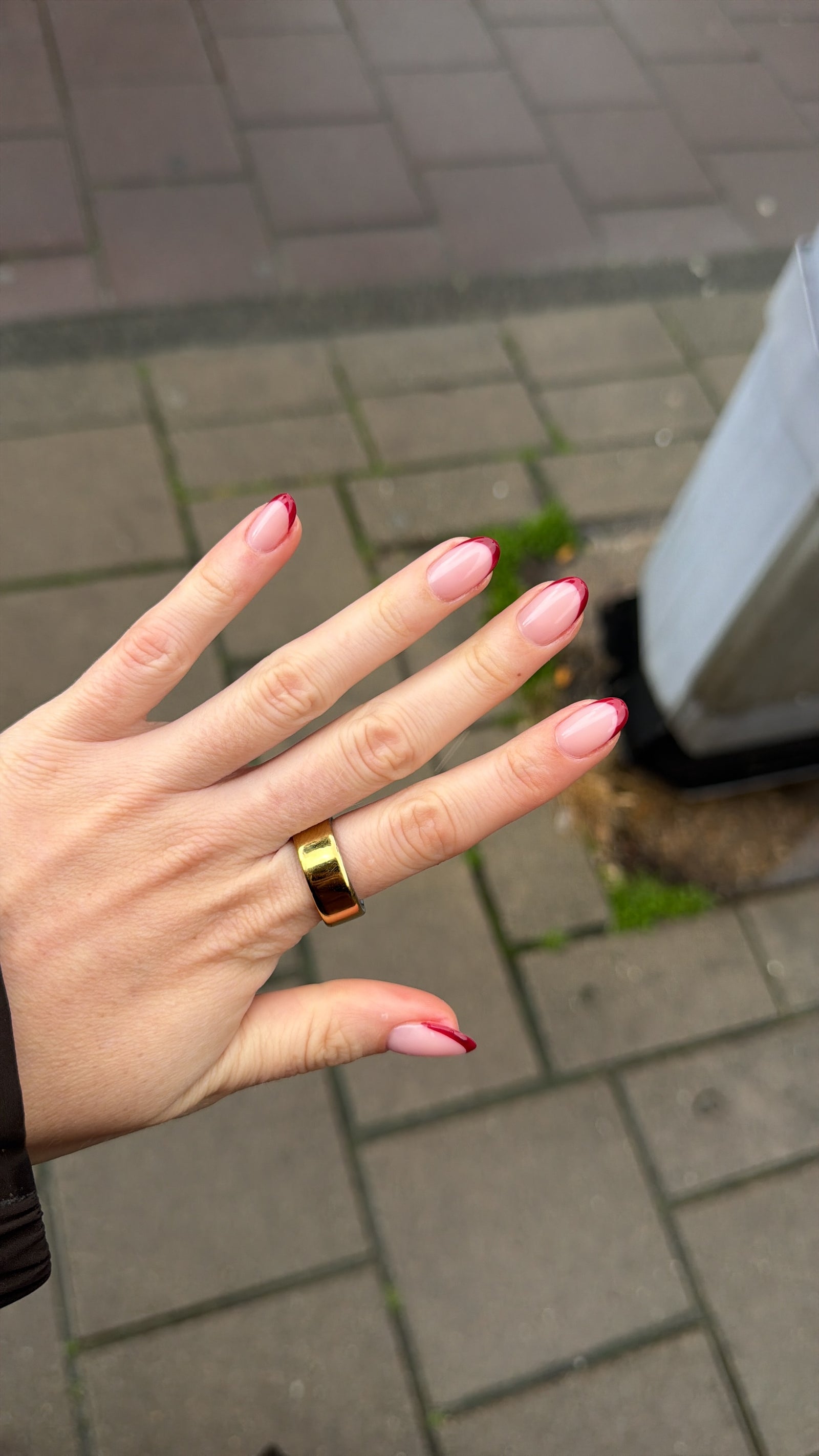 Roze French nagels, hand boven een stoep